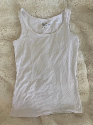 Vitt linne - Basic vitt linne med breda axelband och figurnära passform. Storlek xs, knappt använt. Finns även ett till likadant i min profil.