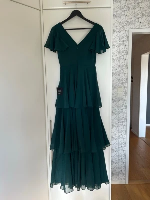 Grön balklänning med volanger - En superfin mörkgrön balklänning med volanger och fladdriga ärmar! 