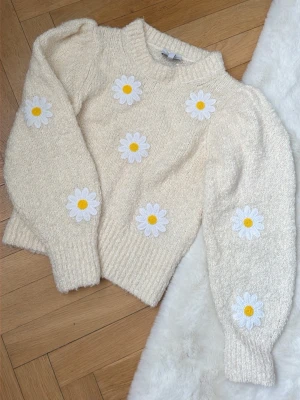 & Other stories - Säljer en krämvit stickad tröja från& other stories med broderade prästkragar i vitt och gult på både fram- och baksida samt ärmar. Tröjan har puffade axlar och är tung och rejäl men ändå luftig. Perfekt sommartröja! Passar både xs & s. 