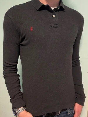 Mörkgrå Ralph Lauren långärmad piké – S - Säljer denna stilrena och snygga mörkgråa Ralph Lauren långärmade pikén. Den är i mycket bra skick och storlek S. Har du några frågor? Tveka inte att höra av dig. Allt gott från Deluxe garderoben ⭐️ 