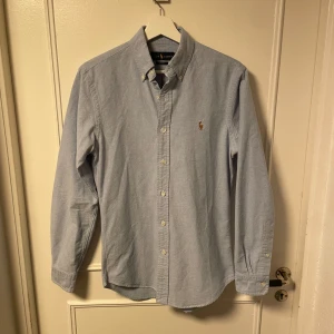 Ljusblå skjorta från Ralph Lauren - En Ralph lauren skjorta i väldigt bra skick, använd endast några gånger men har nu växt ur den. Desto snabbare affär desto bättre pris 