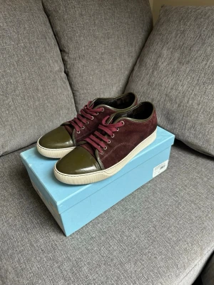 Vinröda och olivgröna Lanvin sneakers - Snygga sneakers från Lanvin i vinrött mocka och olivgrönt lackläder hyfsat bra skick lite slitna under till men inget som är märkbart uk 9 passar 43/44.                                                                                   Hör av dig vid minsta fundering✅