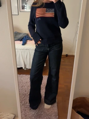 Mörkblå vida jeans - Säljer ett par mörkblå vida jeans med snygga kontrastsömmar och klassiska fickor fram och bak. Jeansen har en hög midja och är tillverkade i ett denimtyg med lite stretch för extra komfort. Perfekta för en avslappnad och trendig look.