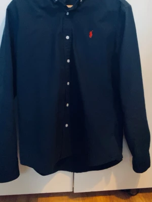 ralph lauren skjorta  - Fin skjorta från Ralph lauren i färgen mörkblå med röd logga skjortan e storlek M som sitter perfekt på 170-180 skjortan är även nyskick inga defekter eller skador pris är ej hugget i sten!