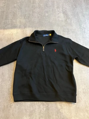 Ralph Lauren half zip  - Säljer en svart RL half zip. Tröjan är aldrig använd och är i nytt skick. Hör av dig vid intresse!!