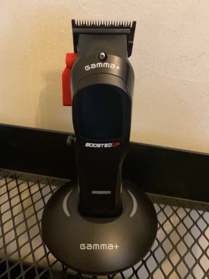 Gamma+ BoostedUp hårtrimmer - Säljer en svart Gamma+ BoostedUp hårtrimmer med laddningsstation. Medföljer laddkabel, skruvmejsel, extra blad och tillbehör. Perfekt för att fixa frisyren hemma eller i salongen.