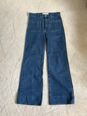 Jeanerica jeans  - Säljer ett par blåa jeans med hög midja och raka, vida ben. Jeansen har stora fyrkantiga fickor både fram och bak samt bälteshällor. Lite för korta för mig därför säljer jag dem, jag är 168cm 