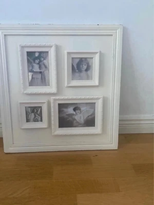 Vit fotoram med fyra bilder - Säljer en stor fyrkantig vit fotoram med fyra inbyggda mindre ramar i olika storlekar. Ramen har klassisk design med dekorativa kanter och svartvita bilder av änglar. Perfekt som väggdekoration eller present.