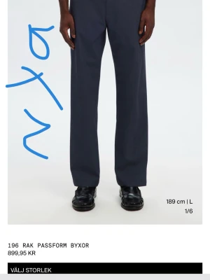 Mörkblå raka kostymbyxor selected  - Snygga mörkblå kostymbyxor från 196 med rak passform och klassisk look. Byxorna har normal midja och är tillverkade i ett mjukt, vävt tyg som ger en stilren siluett. Perfekta för dig som gillar minimalistisk och clean stil. 