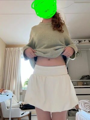 Vit skort med bred midjeresår - Supersöt vit skort med bred midjeresår och voluminös kjoldel. Skorten har en luftig och flowy passform som ger en sportig och trendig vibe. Perfekt för dig som gillar en clean och enkel look.