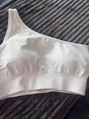 Sport-bh vit - En vit one-shoulder bh/träningstopp från Relode, strl M. Endast använd en gång, vadderad