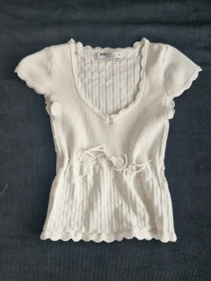 Vit stickad topp - Endast använd två gånger, säljer då den var för liten för mig. 