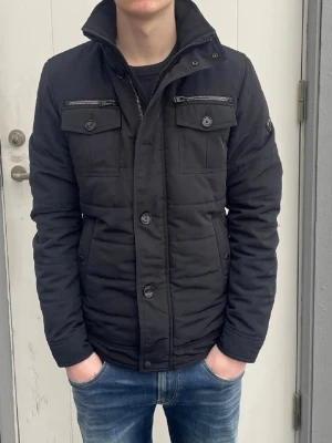 J.lindeberg - Jag säljer den här riktigt snygga fieldjackan från J.lindeberg i storlek S. Den är inte använd mycket alls och är i fint skick utan skador och defekter. Modellen heter Bailey 56 Structured Poly. Nypris på en sån här låg på 3400kr och jag säljer den för 1699. Tveka inte att höra av er!