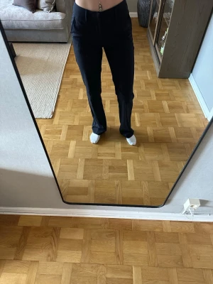 Marinblå randig kostymbyxa från Madlady - Snygga marinblå kostymbyxor med vita tunna ränder.  Byxorna har midwaist och raka ben. Storlek 34/tall. Använda endast ett fåtal gånger. Jag är 168cm