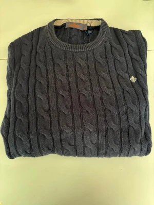 Mörkblå kabelstickad tröja Morris - Mörkblå kabelstickad tröja från Morris med rund halsringning.