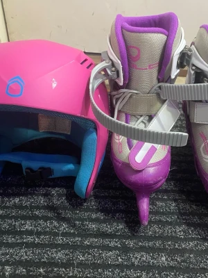 Skridskor och hjälm  - Säljer en rosa hjälm och ett par skridskor i lila, grått och vitt. Skridskorna har spännen så att den passar flera storlekar, snörning för bra passform och hjälmen har blått foder på insidan. Perfekt för dig som vill åka skridskor med stil.