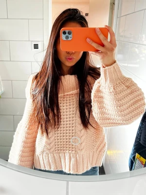 Ljusrosa chunky stickad tröja - Säljer en rosa chunky stickad tröja med breda ärmar och grovt mönster framtill. Tröjan har ribbade muddar och en lös, boxig passform som ger en avslappnad vibe. Perfekt att styla med jeans för en cool look. Obs, har en mörk T-shirt  under vilket man inte ska ha haha🫶🏻