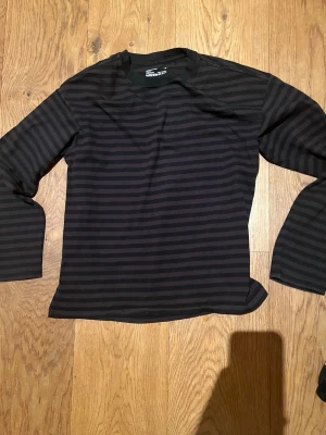 Rutig långärmad tröja fåren weekday  - Snygg randig långärmad tröja från weekday i brunt och svart i storlek XS, Loose boxy fit. Väldigt skön och bra passform. Sitter precis som en sån här tröja borde göra. Tröjan är i gott skick. Skriv vid eventuella funderingar😁