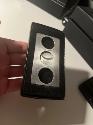 A.jason Cigarrsnoppare  - Säljer en cigarrsnoppare i borstat rostfritt stål med dubbla cirkulära öppningar och ett stilrent, modernt utseende från A.jason. Levereras i en svart ask med vadderad insida. Perfekt för dig som vill ha ett snyggt och funktionellt tillbehör till cigarrerna.