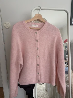 Ljusrosa kofta  - Mysig ljusrosa kofta från Gina Tricot i ullmix. Koftan har rund halsringning, ribbade muddar och knäpps med silvriga knappar framtill. Knappt använd!