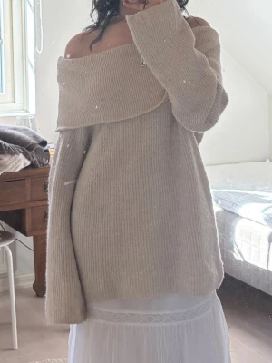 Beige off shoulder stickad tröja 💓 - Jättesöt beige stickad tröja med bred off shoulder-krage och långa ärmar. 💕💕 Oversized passform och ribbstickat material som ger en mysig och avslappnad look ! Inga defekter på själva tröjan
