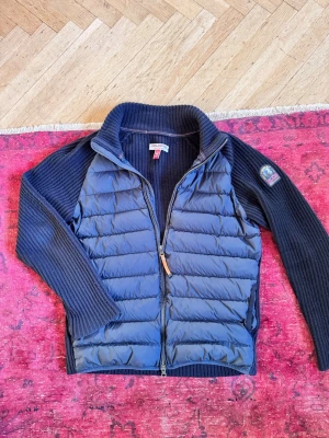 Parajumper cardigan - Säljer nu min parajumper olmo cardigan. Den har dun på framsidan och är stickad på ryggen. Superfint skick med inga som helst skador. Köpte den ny för 6000. Hör av er vid frågor!