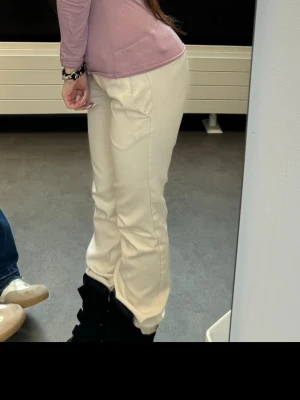 Beiga raka byxor i bomull - Snygga beiga byxor med rak passform och hög midja. Tillverkade i mjukt bomullsmaterial som ger en clean och stilren look. Perfekta att matcha med sneakers eller boots för en chill vibe.