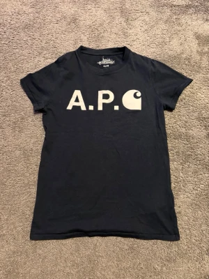 A.P.C x Carhartt T-shirt  - Sjukt snygg sällsynt T-shirt med en collab mellan dem två ikoniska varumärkena A.P.C och Carhartt. Tröjan är i mycket fint skick, det enda är att trycket är pyttelite använt, men det är inget som märks vid användning och det ger bara tröjan lite mer karaktär vilket gör den ännu snyggare enligt mig. Frågor? Bara att skriva✅ Allt gott, mvh Noah