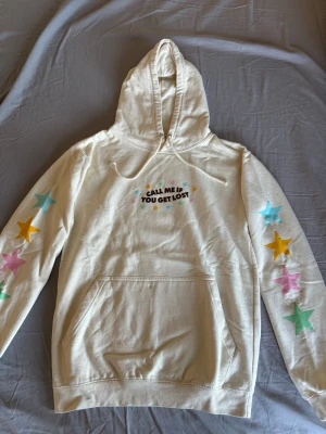 Tyler, the creator hoodie - Beige hoodie från Golf Wang med texten 'CALL ME IF YOU GET LOST' och färgglada stjärnor på bröstet och längs båda ärmarna. Hoodien är helt oanvänd.