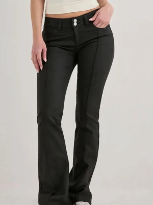 Svarta bootcut jeans med låg midja - Snygga svarta bootcut jeans med hög midja och dubbla knappar framtill. Jeansen har markerade sömmar, klassiska fickor och utsvängda ben. Perfekta för dig som vill ha en trendig och bekväm look.