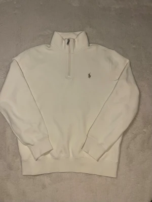 Vit quarter zip från Ralph Lauren - Snygg vit quarter zip tröja från Polo Ralph Lauren, tröjan är i mycket bra skick knappt använd. Då den varit lite för liten för mig. Det står M på tröjan men skulle säga att den passar mer S. Den är även 100% äkta 