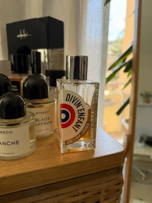 Divin'Enfant parfym från Etat Libre d'Orange 100ml - Divin'Enfant från Etat Libre d'Orange är en unik parfym i en genomskinlig, fyrkantig glasflaska med en cool grafisk etikett i vitt, rött och blått. Flaskan har en silverfärgad metallkork och modern design som sticker ut på hyllan. Nypris: 1715. 55ml/100ml kvar