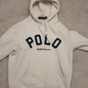Vit hoodie från Polo Ralph Lauren - Vit polo hoodie från Ralph Lauren. Kvitto kan följas med om det önskas. Tröjan sitter bäst om du är mellan 173-178. Hoodien är använd väldigt liten och är iprincip helt ny