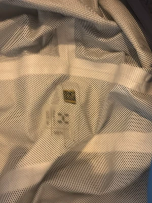 Svart och blå vindjacka från Haglöfs - Snygg vindjacka från Haglöfs i svart med blå detaljer. Jackan har dragkedja framtill och Haglöfs-logga på bröstet. Tillverkad i lätt och slitstarkt material som passar perfekt för utomhusaktiviteter. Enkel och sportig design.