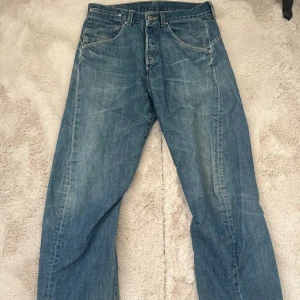 Levi's blå jeans - Blå Levi's jeans med lite baggy passform och femficksdesign med snygg vriden söm framtill. Några defekter längst ner då de är lite långa så har släpat i marken. Skriv för fler bilder