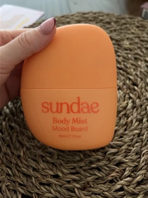 Sundae Body Mist Mood Board 90ml - Fräsch body mist från Sundae i modellen Mood Board. Flaskan är orange och har en rundad, modern form. Doften är fruktig med noter av svartvinbär, passionsfrukt, bergamott, citron, fresia, magnolia, bär, persika, pion, ros, ekmossa, amber och cederträ. Innehåller 90 ml.