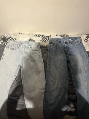Två par raka jeans i olika blå nyanser - Säljer två par raka jeans, ett par i ljusblå tvätt och ett par i klassisk mellanblå tvätt. Båda har femficksmodell och hög midja, perfekta till en avslappnad streetstil. Materialet är denim i bomull. Båda jeansen är från Weekday 
