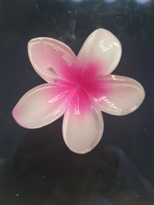 Rosa blomformad hårklämma - Söt hårklämma i form av en blomma med fem kronblad i vitt och rosa. Klämman har en mjuk övergång från vitt till starkt rosa i mitten och är tillverkad i plast. Perfekt för att piffa upp frisyren med en färgglad detalj.