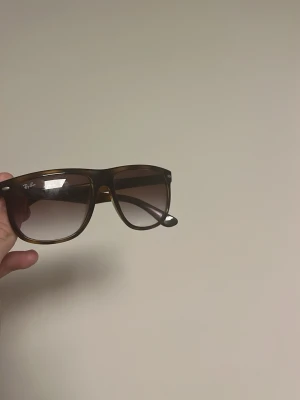Bruna Ray-Ban solglasögon Wayfarer - Säljer ett par klassiska Ray-Ban solglasögon i Wayfarer-modell med brunt plastbåge och tonade bruna glas. Snygg och tidlös design som passar till det mesta. Ray-Ban-loggan syns på linsen för extra stilpoäng.