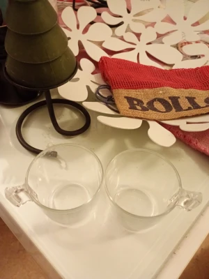 Två genomskinliga glaskoppar - Säljer två stilrena koppar i genomskinligt glas med små handtag. Perfekta för te, kaffe eller varm choklad. Kopparna har en enkel och modern design som passar in i de flesta kök. Säljes som ett set om två.