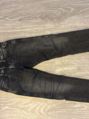 Svarta slim fit jeans med slitningar - Säljer ett par svarta slim fit jeans med snygga slitningar och tvättade detaljer. Jeansen har klassisk femficksmodell och smal passform. Perfekta för dig som gillar en avslappnad men trendig look. Kvitto medföljer, kom med frågor och prisförslag 