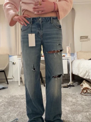 Low rise baggy Zara jeans  - Säljer ett par skitsnygga low rise baggy jeans från Zara med hål, med prislapp!!                                                Midjemått rakt över: 42,5 cm Innerbenslängd: 85 cm 💞💞