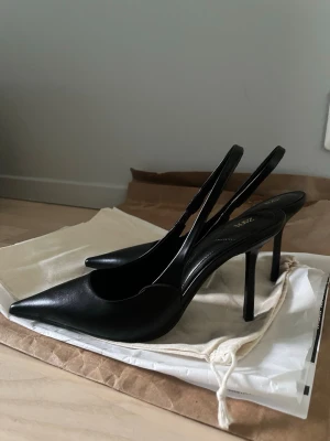 Svarta klackar med öppen häl - Säljer dessa så sjukt snygga svarta klackarna med trendig öppen häl ifrån Zara. Dem är helt nya i storlek 38 och 10,5cm hög klack! Säljer vidare eftersom dem inte passade mig i storleken  Dust bag finns kvar och även lapparna🖤