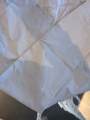 Grå kostymbyxor med pressveck - Snygga grå kostymbyxor med klassiskt pressveck och hög midja. Byxorna har raka ben och resår i midjan för extra komfort. Tillverkade i ett mjukt, vävt material som ger en stilren look.