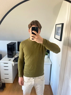 Olivgrön kashmirblandning tröja - Säljer en stilren olivgrön tröja från Tom Tailor med rund halsringning och långa ärmar. Tröjan är tillverkad i 95% bomull och 5% Kashmir. Hör gärna av dig vid frågor!