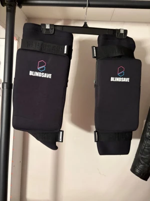 BLINDSAVE svarta knäskydd - Säljer ett par svarta knäskydd från BLINDSAVE, perfekta för innebandy eller annan sport där du behöver extra skydd. De har vadderade paneler, justerbara kardborreband och är tillverkade i ett stretchigt material för bra passform. Snygg logga framtill. Dem har tyvärr ett litet hål på en av dem men annars i bra skick.
