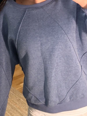 Blå sweatshirt i relaxed fit🎀 - En stilren blå sweatshirt med rund hals och breda muddar vid ärmar och midja. Tröjan har en relaxed fit och är gjord i mjukt bomullsmaterial. Perfekt för en chill och avslappnad look. Ingao synliga loggor eller tryck.