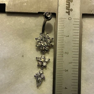✨ NY oanvänd navelpiercing med hänge - Kirurgiskt stål 316L  - ✨ NYTT oanvänt smycke i kirurgiskt stål! 🌸 Hållbart & Rostfritt: Slitstarkt 316L-stål som inte oxiderar eller rostar av fukt. 🌸 Säkert: Industristandard, skonsamt för läkta piercingar.  🛍️ 30 % BUNDLE-RABATT! Köp fler artiklar från min shop och få 30 % på allt! ✨ 📦 Frakt: Endast spårbart via Plick SafePay för vår trygghet.