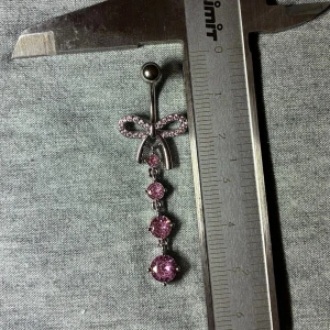 ✨ NY oanvänd navelpiercing med hänge - Kirurgiskt stål 316L  - ✨ NYTT oanvänt smycke i kirurgiskt stål! 🌸 Hållbart & Rostfritt: Slitstarkt 316L-stål som inte oxiderar eller rostar av fukt. 🌸 Säkert: Industristandard, skonsamt för läkta piercingar.  🛍️ 30 % BUNDLE-RABATT! Köp fler artiklar från min shop och få 30 % på allt! ✨ 📦 Frakt: Endast spårbart via Plick SafePay för vår trygghet.