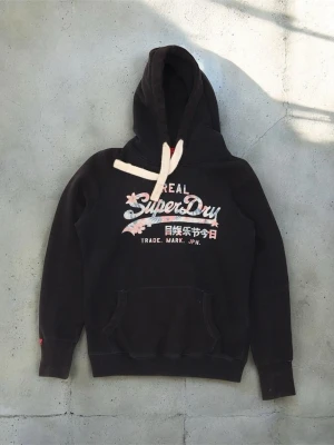 Superdry hoodie M - Säljer en sjukt fet hoodie från märket superdry!!! Hoodien passar till alla outfits, den är stilren och har inga defekter🤩🤩 Storleken är M. Kom privat via fler bilder, tvivla inte att ställa frågor;)